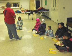 Omar teaching the kids about a healthy plate before they start their fitness fun.